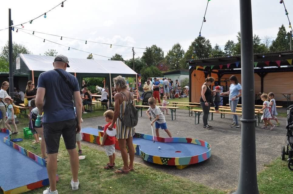 Familien gehen zwischen der Balancierbahn und weiteren Spielstationen umher.