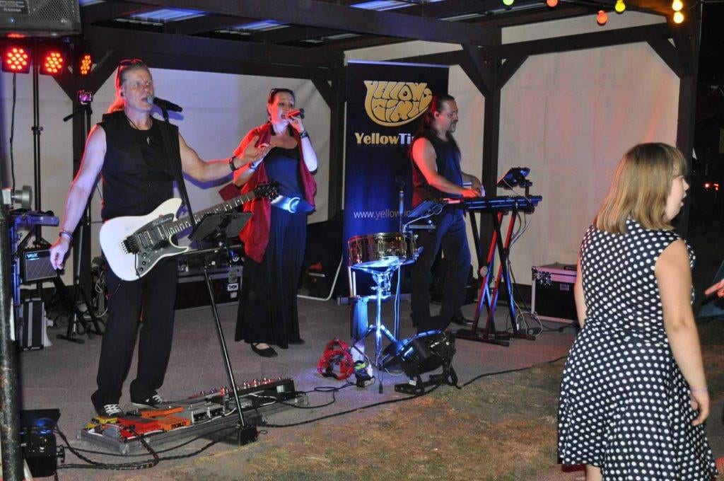 Eine Band spielt am Abend auf der beleuchteten Bühne.