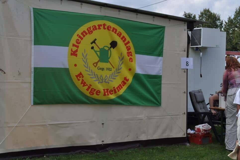 Kinderfest im Kleingartenverein Das grün-weiße Vereinsbanner hängt an einem Feststand.