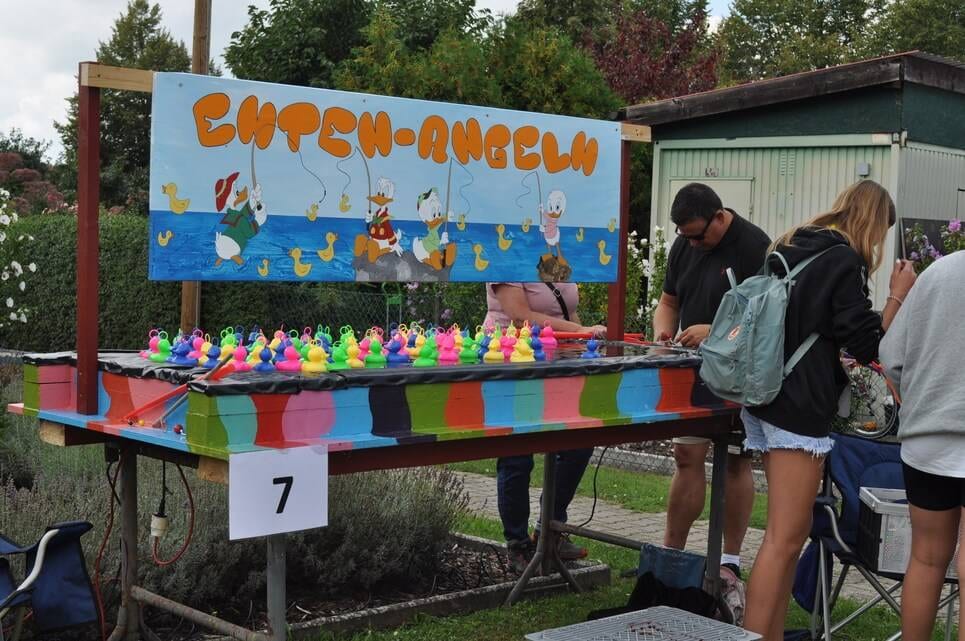 Kinderfest im Kleingartenverein Kinder und Erwachsene stehen am farbenfrohen Entenangel-Stand.