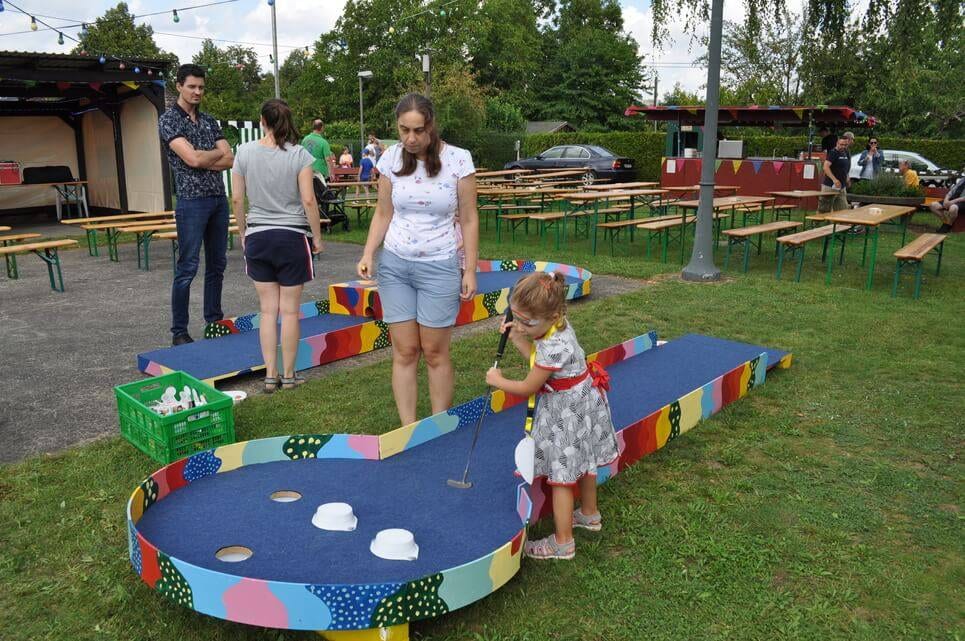 Kinderfest im Kleingartenverein Ein kleines Kind spielt an einer bunt bemalten Balancierstrecke.