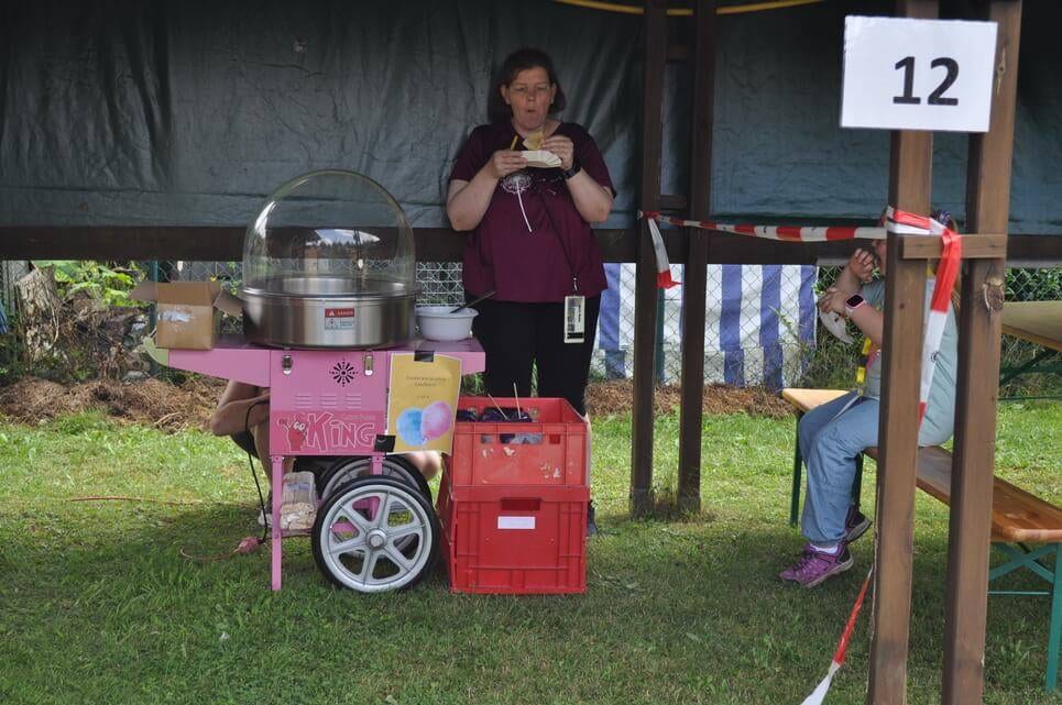 Kinderfest im Kleingartenverein Eine Helferin steht mit einem kleinen Getränkewagen am Spielplatz.