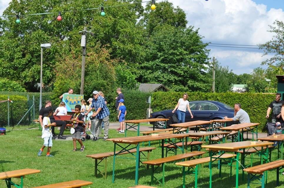 Kinderfest im Kleingartenverein Familien verteilen sich zwischen den Sitzbänken auf dem Festplatz.