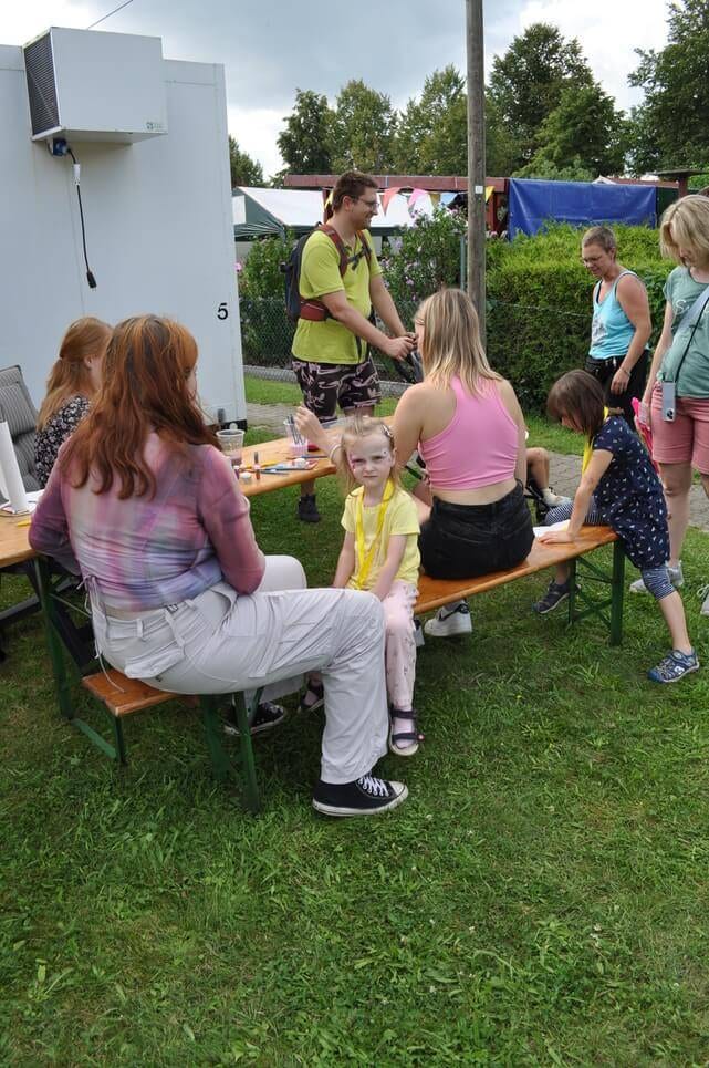 Kinderfest im Kleingartenverein Kinder und Erwachsene sitzen und stehen in einer kleinen Gesprächsrunde.