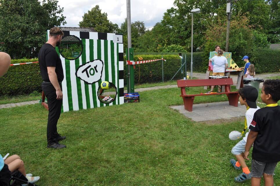 Kinderfest im Kleingartenverein Ein Kind wirft einen Ball auf die grün-weiße Torwand.
