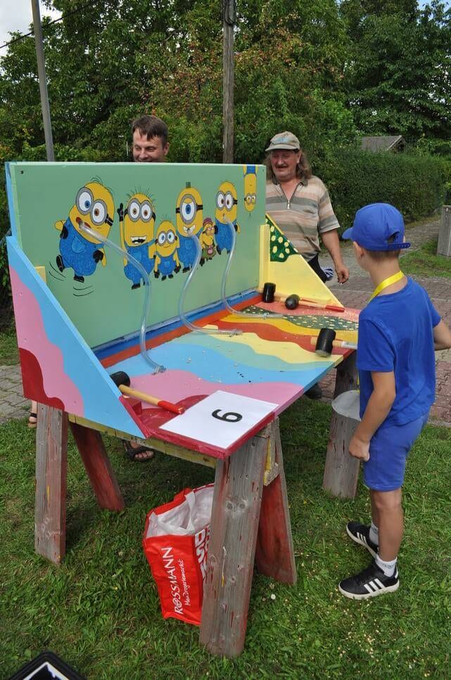 Kinderfest im Kleingartenverein Ein Kind spielt vor der bunt bemalten Minions-Wand.