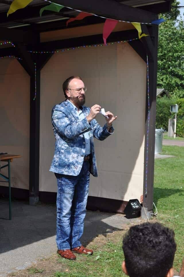 Kinderfest im Kleingartenverein Ein Zauberkünstler führt vor dem Publikum einen Trick vor.