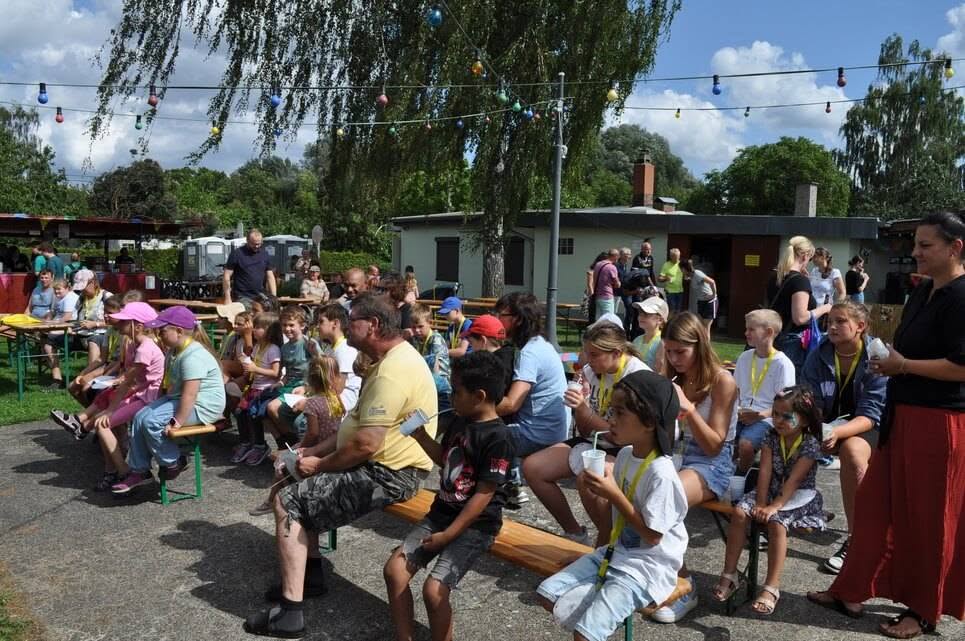 Kinderfest im Kleingartenverein Kinder und Erwachsene verfolgen die Zaubershow von den Sitzbänken aus.