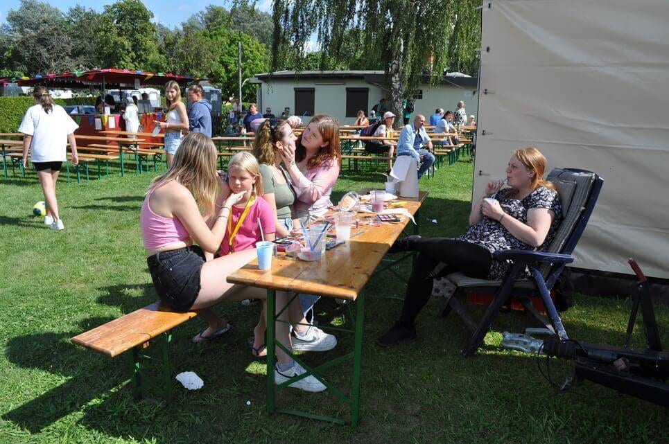 Kinderfest im Kleingartenverein Kinder und Erwachsene sitzen beim Basteln an einem Festtisch.