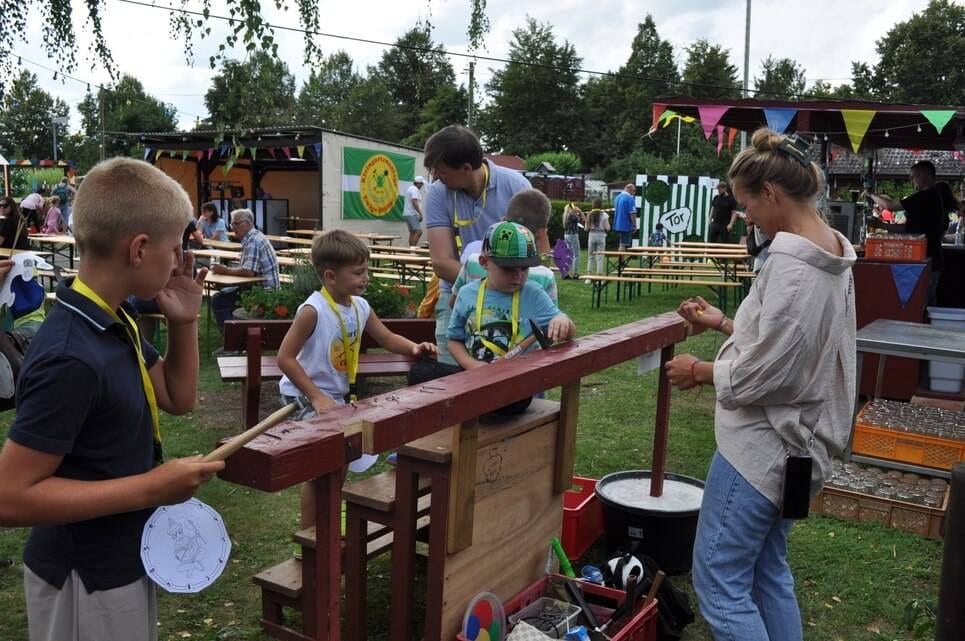 Kinderfest im Kleingartenverein Mehrere Kinder spielen gemeinsam an einer langen Holzspielbahn.