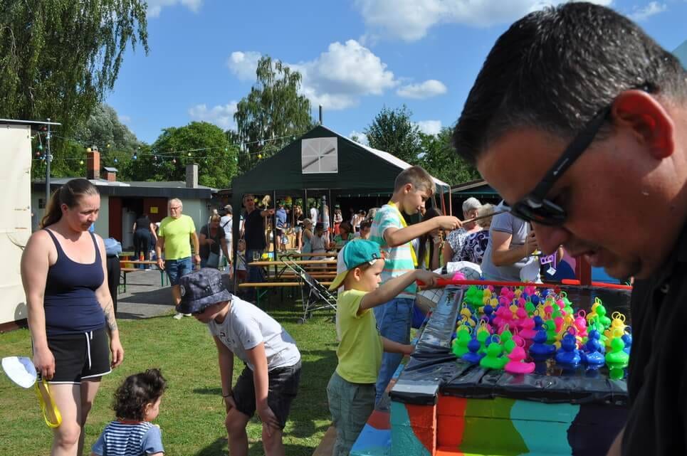 Kinderfest im Kleingartenverein Kinder angeln bunte Spielfiguren aus dem Entenangel-Becken.