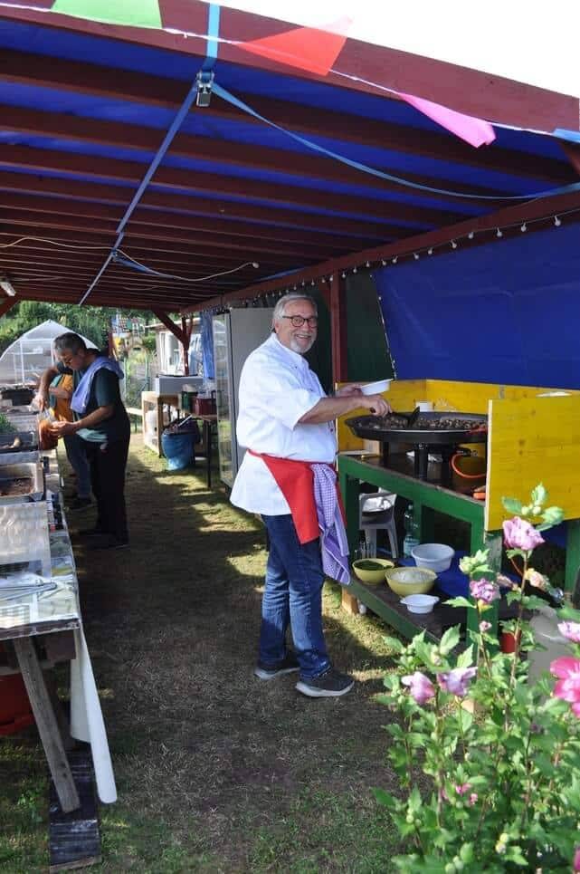Kinderfest im Kleingartenverein Ein Helfer steht am Grill unter einem bunt geschmückten Vordach.